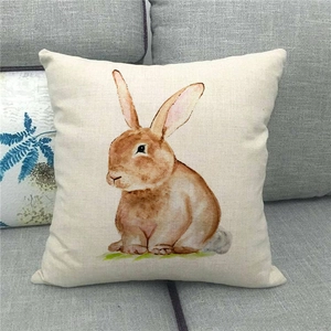Detail eines Leinenkissenbezugs mit Aquarell-Hasenmotiv auf grauem Sofa