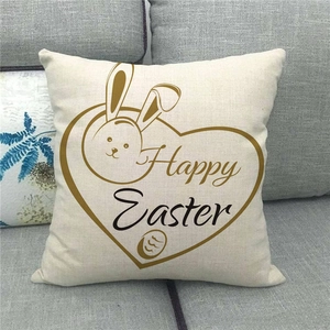 Detail of linen Happy Easter cushion cover featuring rabbit design on a grey fabric sofa