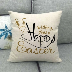 Close-up of Happy Easter linen pillowcase with rabbit print on a gray fabric sofa