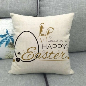 Close-up of Easter linen pillowcase with bunny and eggs on a grey fabric sofa