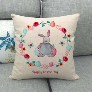 Close-up of Happy Easter Day linen pillowcase with bunny and floral wreath on a sofa