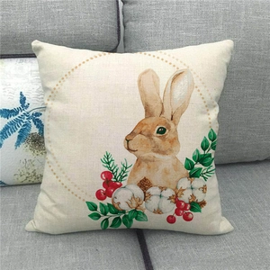 Funda de cojín de Pascua en lino con conejo de acuarela, bayas rojas y algodón en el sofá