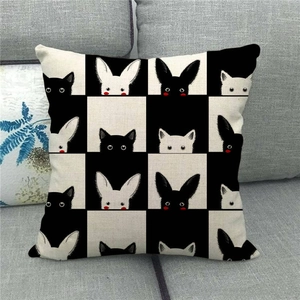 Detail of linen cushion cover featuring black and white checkered animal patterns on a sofa