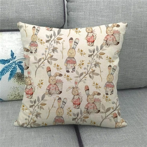 Close-up of linen pillowcase with illustrated Easter bunny patterns on a grey sofa