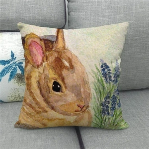 Detail of linen pillowcase featuring a watercolor bunny and lavender on a gray sofa
