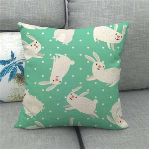 Close-up of linen pillowcase with mint green cartoon rabbit and white polka dot pattern