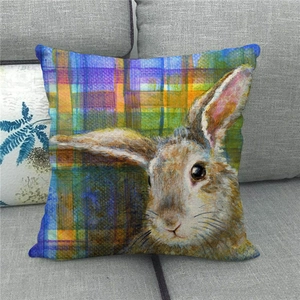 Detail of linen Easter cushion cover with bunny design on a gray sofa fabric
