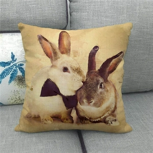 Detail of vintage linen pillowcase featuring artistic Easter rabbits on a grey sofa