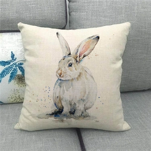 Detailed macro view of the linen texture and watercolor rabbit print on a throw pillow