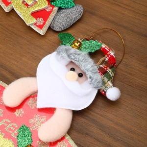 Detail of plush Santa ornament with red plaid hat, golden bell, and glitter base
