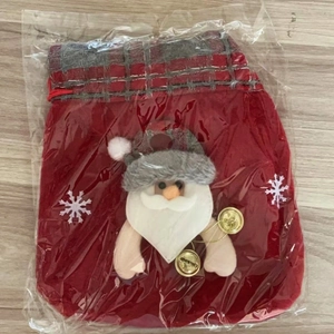 Detail of red velvet Christmas gift bag with 3D Santa Claus figure and gold bells