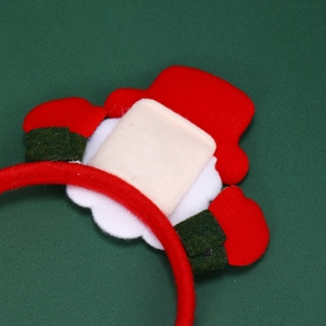 Close-up of a glowing Christmas headband with felt Santa hat and small hand details