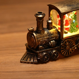 Macro view of vintage Christmas train ornament featuring Santa and an LED glowing tree