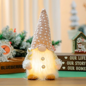 Close-up of glowing LED Christmas gnome with knitted hat and warm light effect