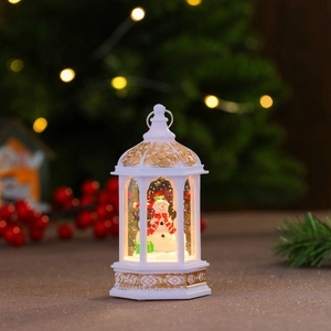 Dettaglio di una lanterna di Natale bianca con pupazzo di neve e luce LED calda
