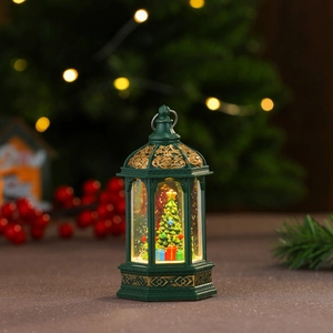 Dettaglio di lanterna di Natale verde vintage con albero innevato e luce calda a LED
