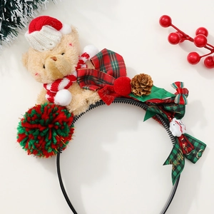 Détail du serre-tête de Noël avec ours en peluche, nœud écossais, pommes de pin et baies rouges