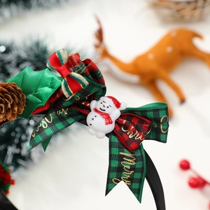 Détail du serre-tête de Noël avec nœud écossais, bonhomme de neige et pomme de pin décor