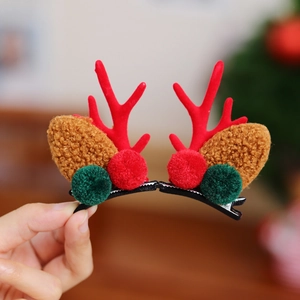 Détail de pinces à cheveux bois de renne avec flocage rouge et pompons doux