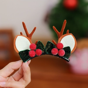 Détail d'une pince à cheveux renne de Noël avec nœud en velours et baies rouges givrées
