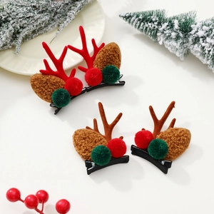 Détail de pinces à cheveux bois de renne de Noël avec pompons sur branches enneigées