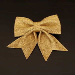 Detailed view of glittering gold Christmas bow with sparkling sequins and metallic finish