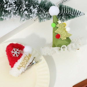 Close-up of Christmas antler hair clips featuring plush Santa hat and sparkling Xmas tree