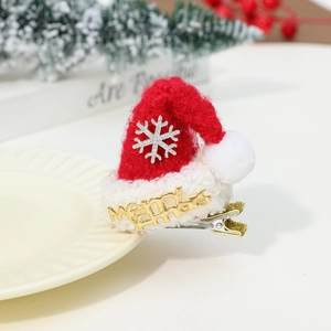 Detail of Christmas hair clip featuring a mini Santa hat with Merry Christmas gold text