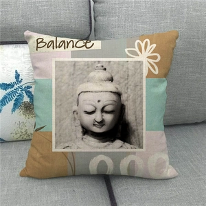 Detail des Leinen-Kissenbezugs mit Buddha-Motiv und Balance-Text auf grauem Sofa