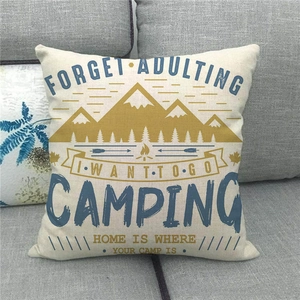 Close-up of linen camping pillowcase with mountain and campfire print on grey sofa