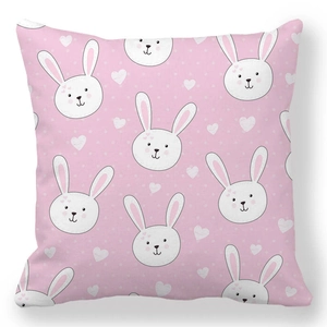 Detail shot of soft peach skin cushion cover with cute white rabbits and heart patterns