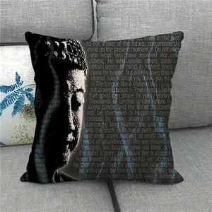 Detail eines Leinenkissenbezugs mit weißem Buddha-Gesicht und Text auf schwarzem Grund