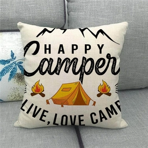 Linen cushion cover with HAPPY Camper tent design displayed on a grey fabric sofa