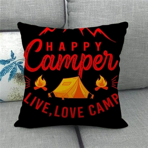 Detail of Happy Camper linen pillowcase on sofa featuring tent and bonfire graphics