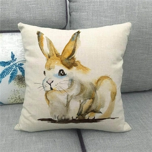 Detail of linen pillowcase with watercolor Easter bunny print on a grey sofa