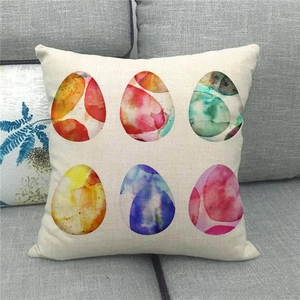 Detail of linen pillowcase with six colorful watercolor Easter eggs on a grey sofa