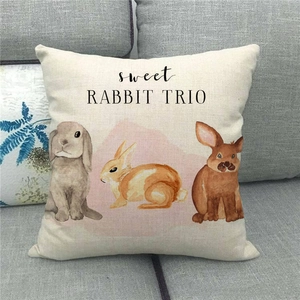 Primer plano de funda de cojín de lino de Pascua con estampado de tres conejos