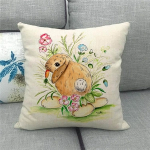 Detailed view of linen pillowcase with watercolor rabbit and floral pattern on a gray sofa