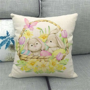 Detalle de funda de cojín de lino con conejo de Pascua, huevos y flores en un sofá gris