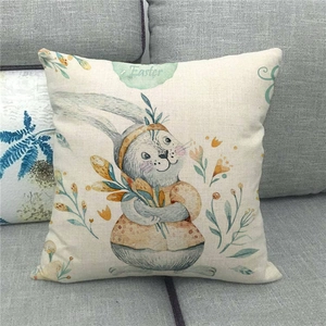 Primer plano de funda de cojín de lino de Pascua con conejo y flores sobre un sofá