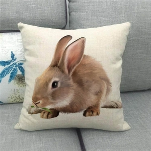Close-up of linen Easter pillowcase featuring a realistic brown rabbit on a gray sofa