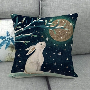 Detail of Easter pillow cover with white rabbit and golden moon on a gray sofa