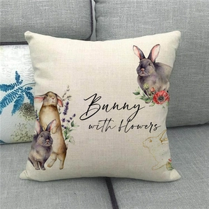 Close-up of linen pillowcase with watercolor bunny and floral design on grey sofa