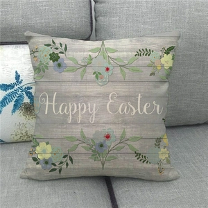 Close-up of linen Happy Easter pillowcase with floral patterns on a gray sofa