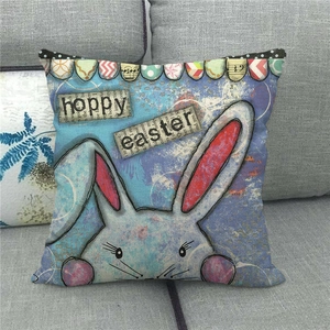 Detail of linen Easter pillow cover with rabbit design on a gray fabric sofa