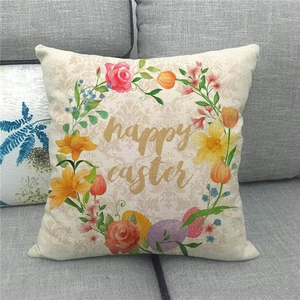 Close-up of Happy Easter linen pillow cover with floral wreath on a grey sofa