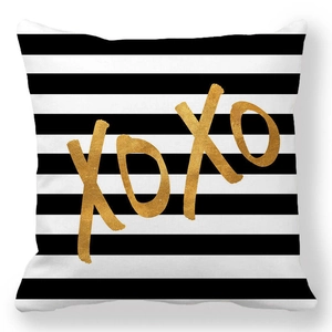 Détail d'une taie d'oreiller à rayures noires et blanches avec lettrage XOXO doré