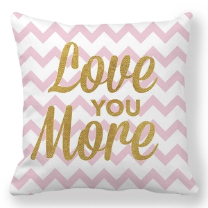 Détail d'une taie d'oreiller rose à chevrons avec lettrage doré Love You More brillant