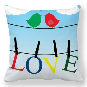 Détail de l'imprimé LOVE et des oiseaux colorés sur la housse de coussin en velours