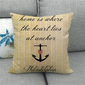 Detailed texture of herringbone linen pillowcase with home quote and anchor print on sofa